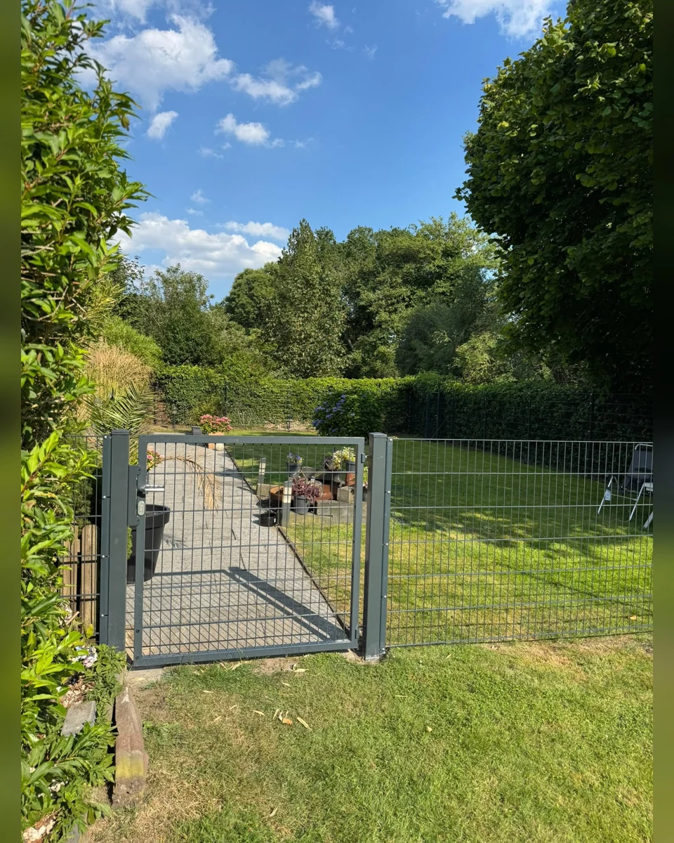 Originalfoto einer Zaunonkel-Gartentür vor Rasen und Hecken in Collinghorst, Rhauderfehn